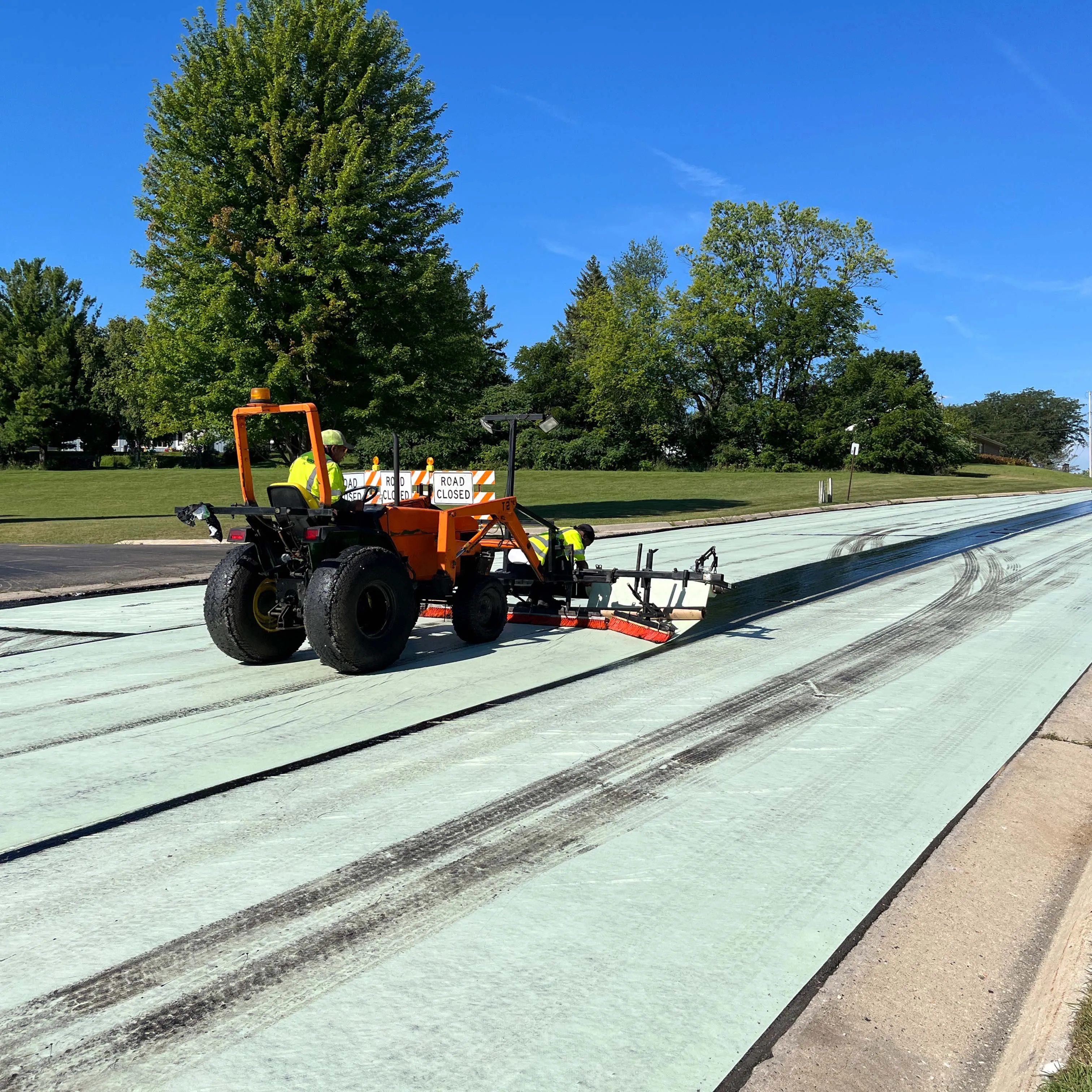 Road Fabrics crew installing a paving interlayer with specialized equipment